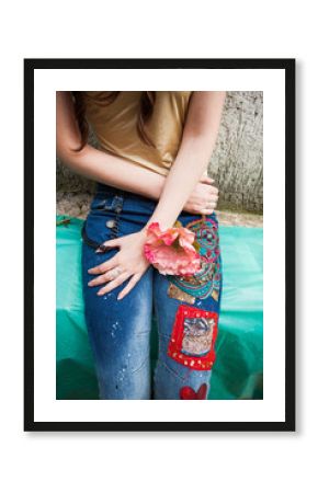 closeup of young woman in boho style blue jeans with colorful applications lower body
