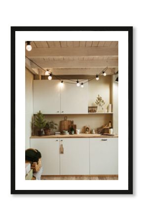 Home kitchen interior with Christmas celebration decorations: garland lights, fir branches.