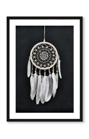 Beautiful handmade boho styled dreamcatcher with white feathers and beads against black.