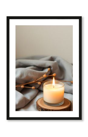Meditation space with scanted candle. Burning candle on wooden coaster. Warm interior aesthetic composition with dry boho branch and grey fabric. Home comfort, spa, relax and wellness concept, banne