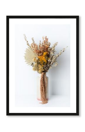 Stylish modern dried flower arrangement in a cream and pink vase. Including Native Temp, Palm frond, Kangaroo paw and Amaranthus. Photographed on a white background.