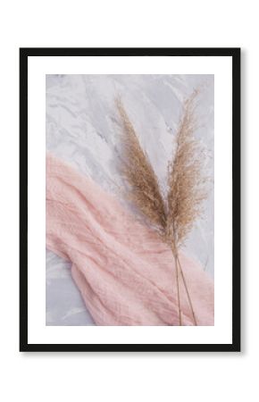 Dried natural pampas grass on pink surface background. Minimal concept. Flat lay, copy space, top view. The aesthetics of wabi sabi. Natural material.