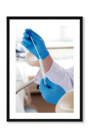 Lekarz w niebieskich rękawiczkach pobiera materiał do cytologii. 