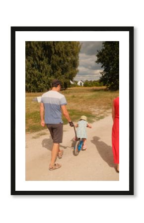 Ojciec uczy dziecko jeździć na rowerze