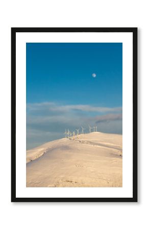  wind generators on a snow covered mountain. Big moon visible 