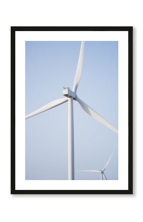 Wind turbine against clear blue sky for green energy