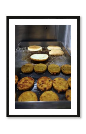 hamburguesas vegetales y ecológicas friéndose a la plancha con panecillos de brioche
