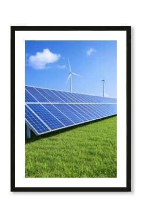 Solar panels and wind turbines in a green field under a blue sky.