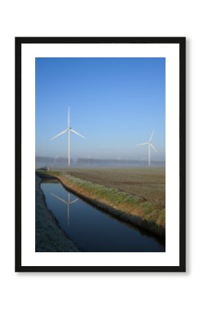 Wind turbines in a frosty countryside landscape in the Netherlands during winter