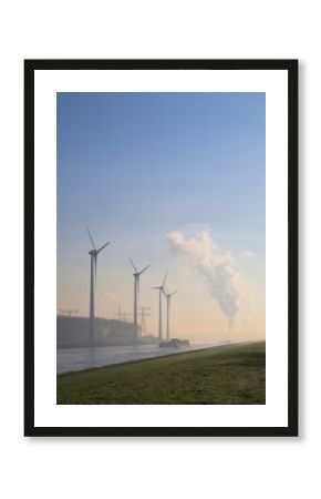 Wind turbines and chemical industry along a canal in the Netherlands