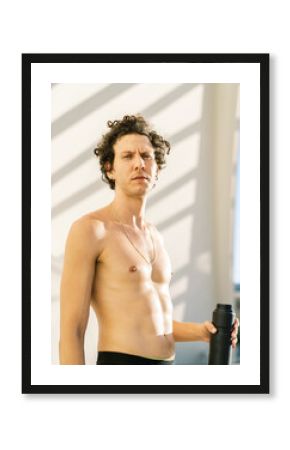 Shirtless athlete standing in sunny day
