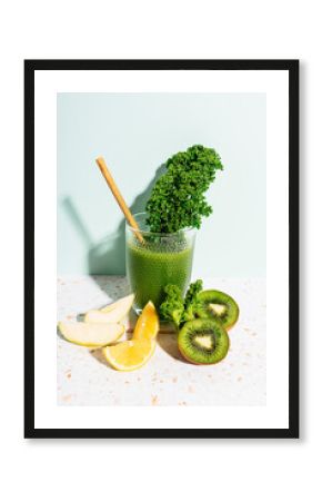 Healthy green juice with apple, lemon, kale, kiwi and celery against wall