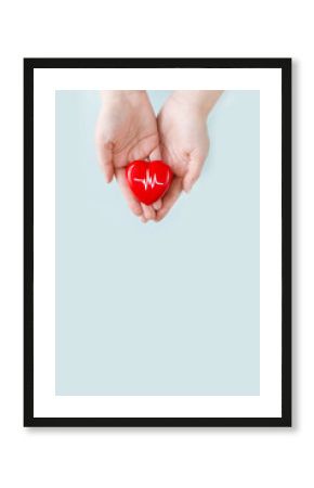 World Hypertension Day. Adult holds a red heart with a heartbeat chart with his hands - a symbol of high blood pressure. Hypertension Day in May 17th. World heart day, world health day.