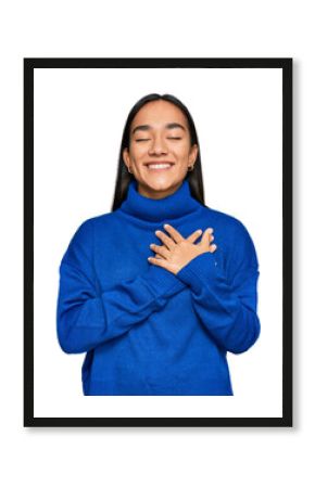 Young asian woman wearing casual winter sweater smiling with hands on chest with closed eyes and grateful gesture on face. health concept.