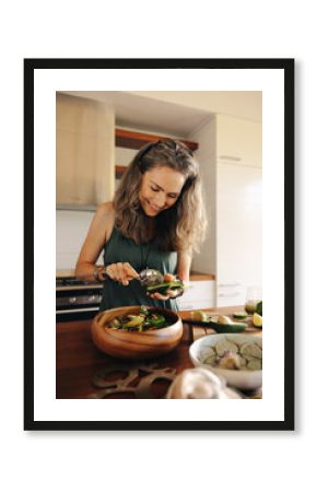 Happy vegetarian woman preparing a delicious buddha bowl at home