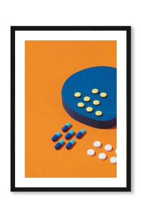 Creative layout with pills and bottle on two tone orange and blue