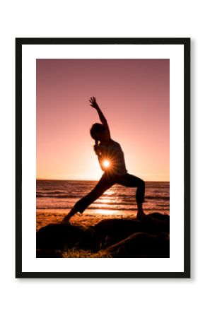 Woman Silhouetted Practicing Yoga on the Beach at Sunset