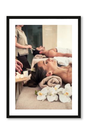 Relaxed woman lying down on massage bed during facial treatment at Asian spa and wellness center