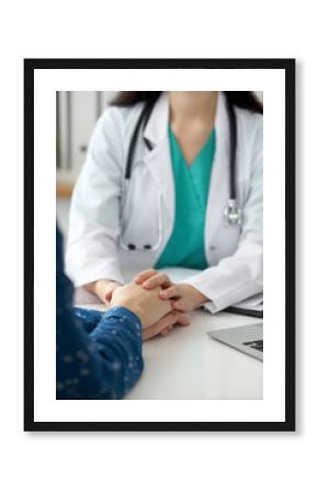 Close-up of doctor  reassuring her female patient. Medical ethics and trust concept