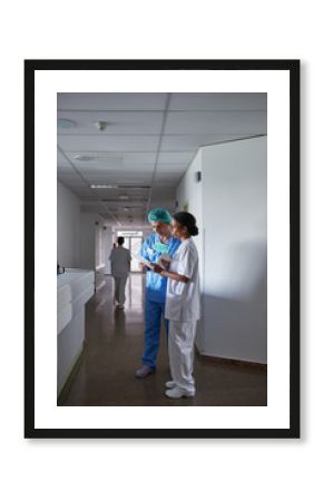 Multiethnic doctors reading a pacient diagnosis in a hospital hallway
