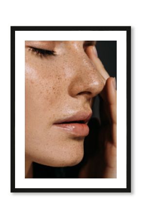 close up view of tender woman with freckles on face isolated on grey