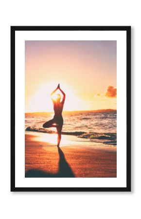 Yoga wellness retreat class on morning sunrise beach landscape. Silhouette of girl standing in tree pose meditation vertical background.