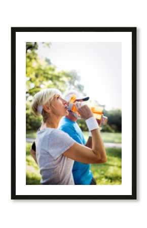 Mature or senior couple doing sport outdoors, jogging in a park