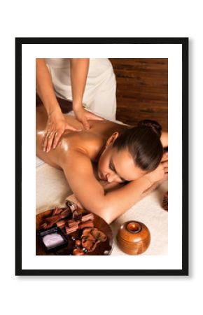 Masseur doing massage on woman body in the spa salon.