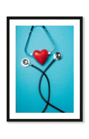 Top view of decorative red heart with black stethoscope on blue background, world health day concept