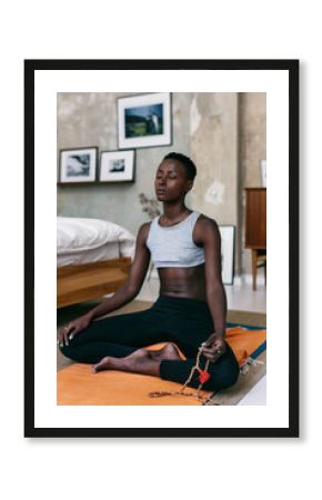 Young woman meditating in bedroom