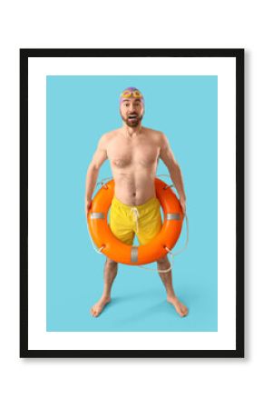Male swimmer with ring buoy on blue background