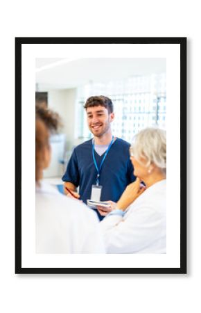 Smiling nurse taking notes while talking with medical team in hospital