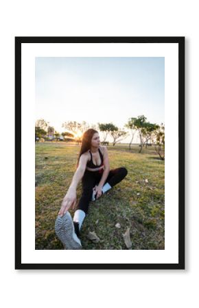 Latina stretching on grass in urban park, Asuncion, Paraguay