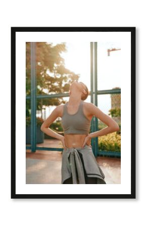 Young woman stretching outdoors in athletic wear, enjoying the sunlight