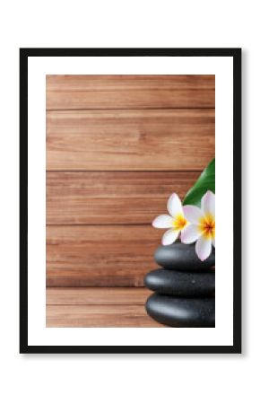 Relaxation self-care wellness. Stacked stones with flowers on a wooden background.