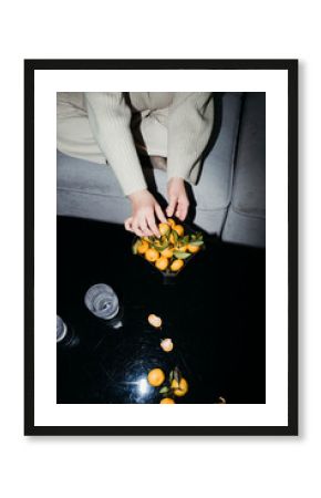 Hands Delicately Arranging Citrus Fruits in a Bowl