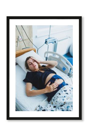 A young woman has almost given birth to a baby. A woman in labor. A delivery room in a maternity hospital.