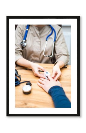 Nurse checks patient vitals in clinic. Medical professional measures patient's pulse and vitals during a consultation in a healthcare setting.