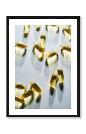 Yellow Softgel Capsules with Shadows on White Surface