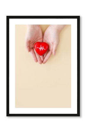 World Hypertension Day. Adult holds a red heart with a heartbeat chart with his hands - a symbol of high blood pressure. Hypertension Day in May 17th. World heart day, world health day.