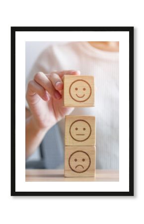 Hand choosing smile face from Emotion block for customer review, good experience, positive feedback, satisfaction, survey, evaluation, assessment, mood, world mental health day concept