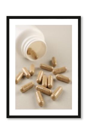 Bottle and vitamin capsules on light background, closeup