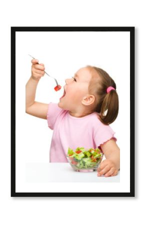 Cute little girl eats vegetable salad