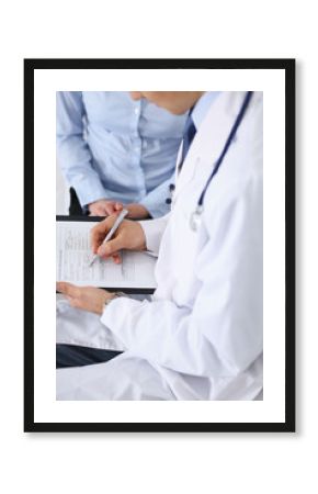 Male doctor holding application form while consulting female patient in hospital. Medicine and healthcare concept