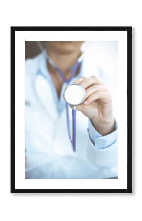 Unknown doctor woman holds stethoscope head, close-up. Physician ready to examine and help patient. Helping and insurance in health care, best treatment and medicine concept