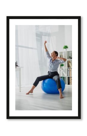 beautiful happy businesswoman stretching on fitness balls in office