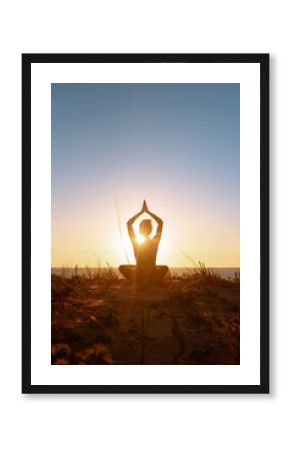 Silhouette meditation girl on the background of the stunning sea and sunset. Yoga, fitness and healthy lifestyle. Woman doing meditation in the beach. Vertical stock photo
