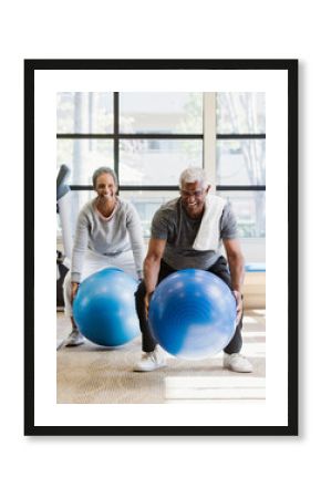 happy senior couple exercising in gym