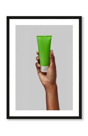 Woman holding a green cream tube