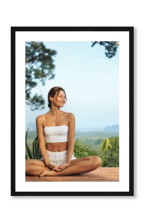 Smiling Woman In Lotus Pose Outdoors With Scenic Jungle And Sky View